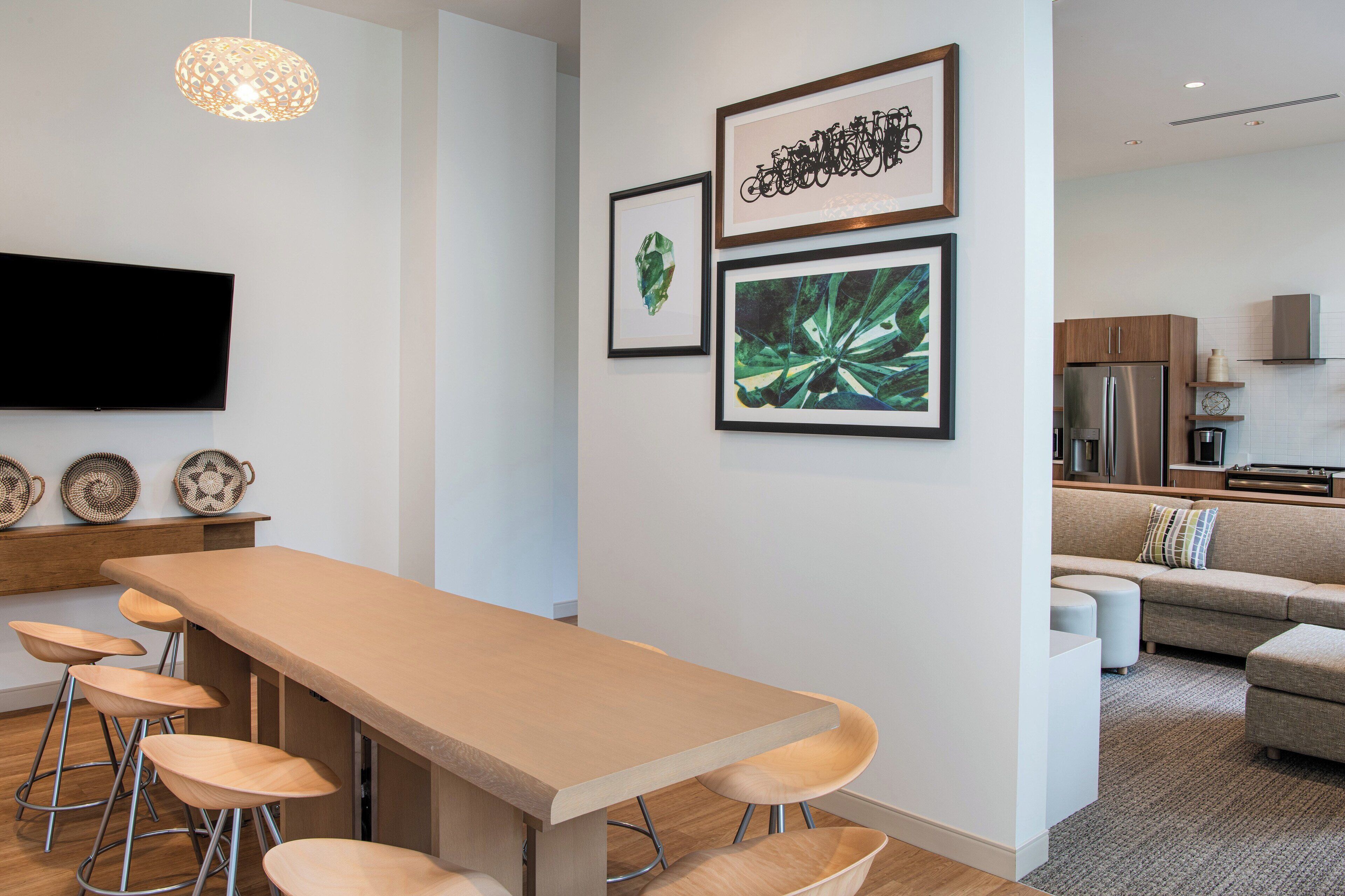 A modern kitchen with a stainless steel refrigerator, wooden cabinets, and a built-in oven.