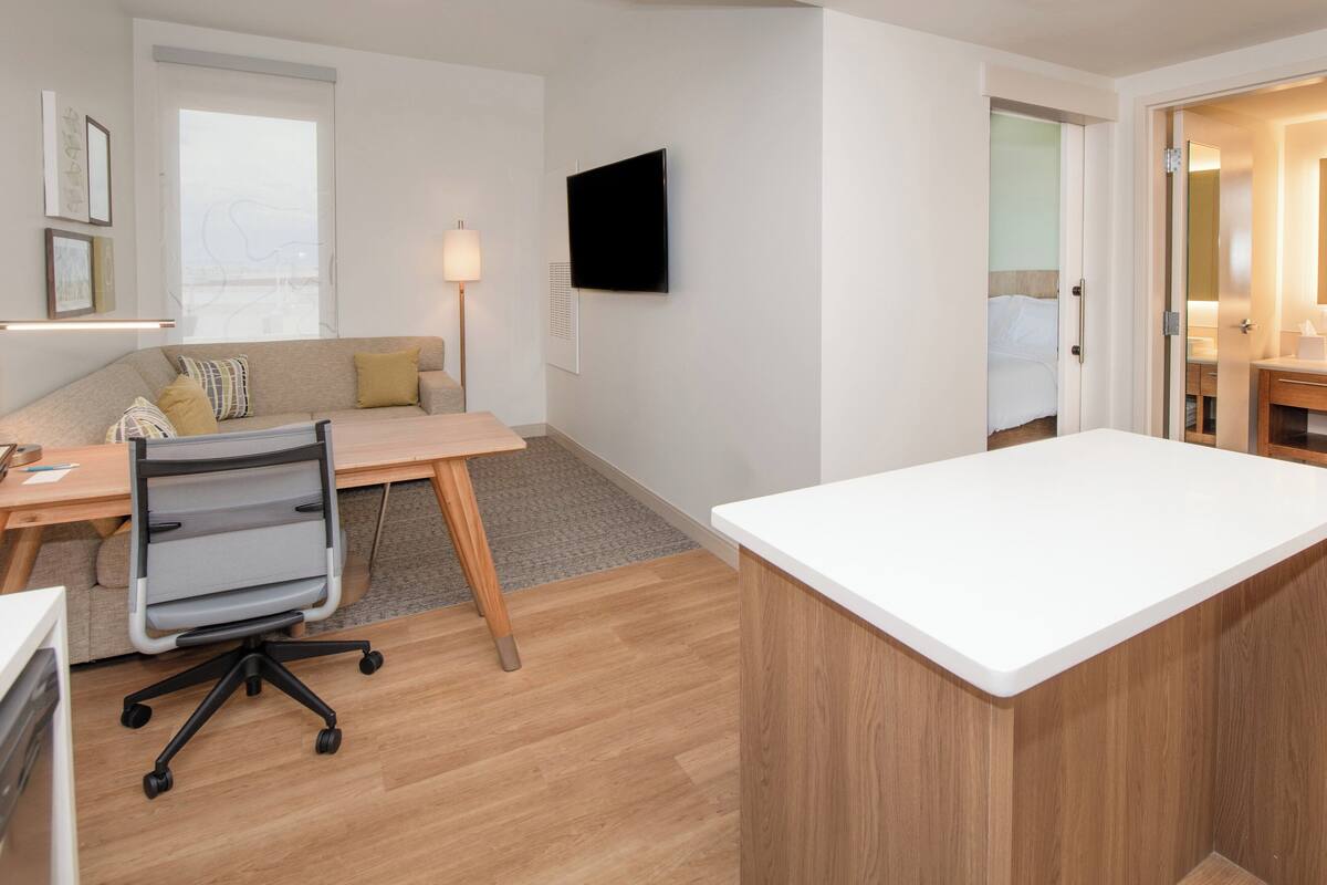 A modern office space with a wooden desk, office chair, and a white reception desk.