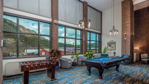 A pool table, foosball table, and large windows with a mountain view. - MountainSide Resort near Zip Lining and Museums (Durango)