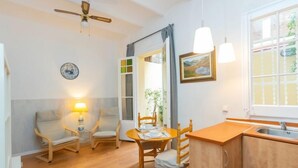 Una cocina acogedora con muebles de madera, una mesa de comedor y una ventana con vistas a la vegetación.