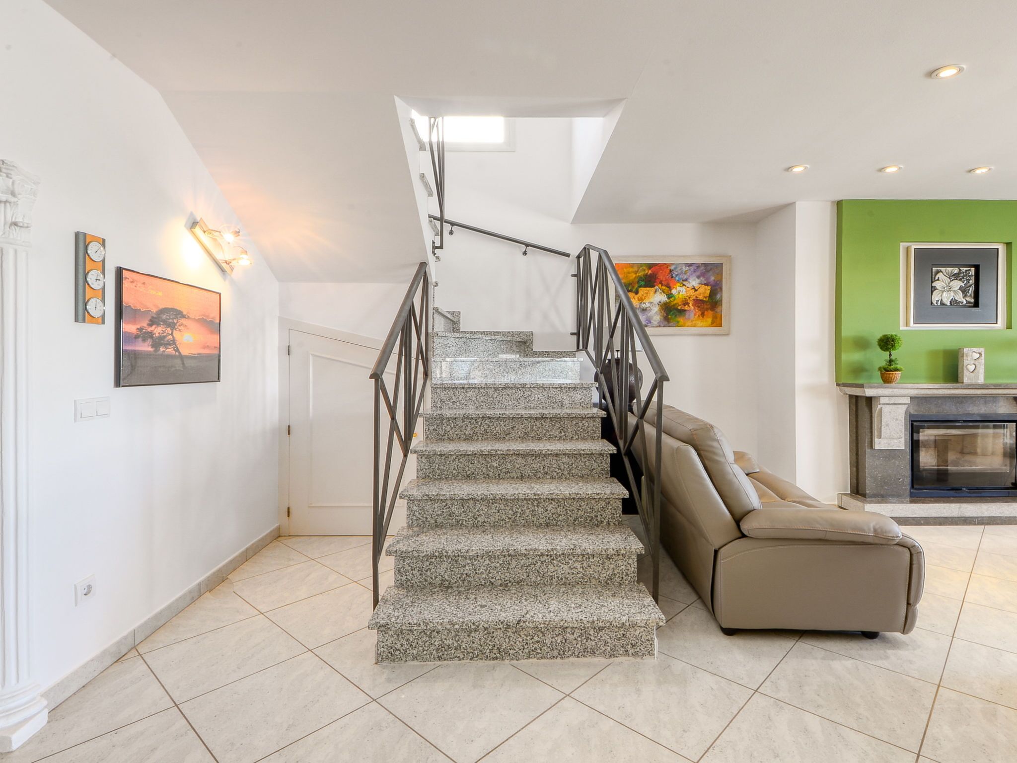 Un escalier avec une rampe métallique menant à un palier.