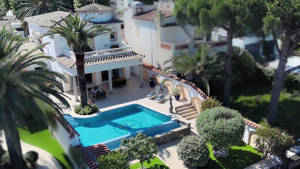 Une maquette d’un quartier résidentiel comprenant une piscine, des palmiers et une maison à deux étages dotée d’un balcon.