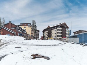 A snowy urban area with buildings, including a restaurant and a hotel.