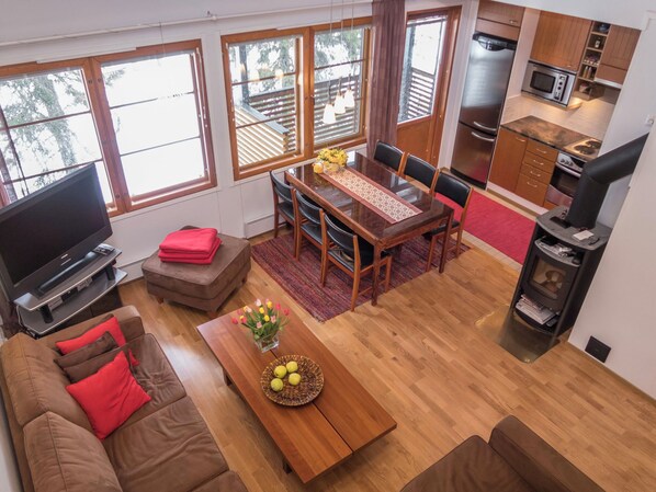 A compact living space with a dining area, kitchenette, and a TV in the living room.