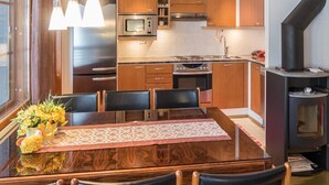 Une cuisine moderne avec des meubles en bois, un four à micro-ondes, une cuisinière et un poêle à bois.