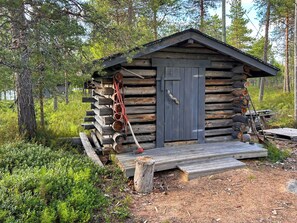 A rustic cabin with a wooden door, a porch, and a small deck.