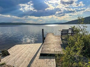 A wooden dock extending into a calm lake with a bench and a table on the right side. - Nanguvilla by Interhome (Inari)