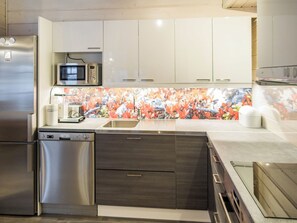 A modern kitchen with stainless steel appliances, a microwave, and a dishwasher.