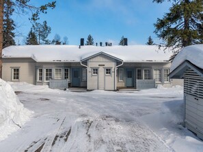 A two-story building with a symmetrical facade, a central entrance, and a snow-covered driveway. - Nelikko b by Interhome (Kuusamo)