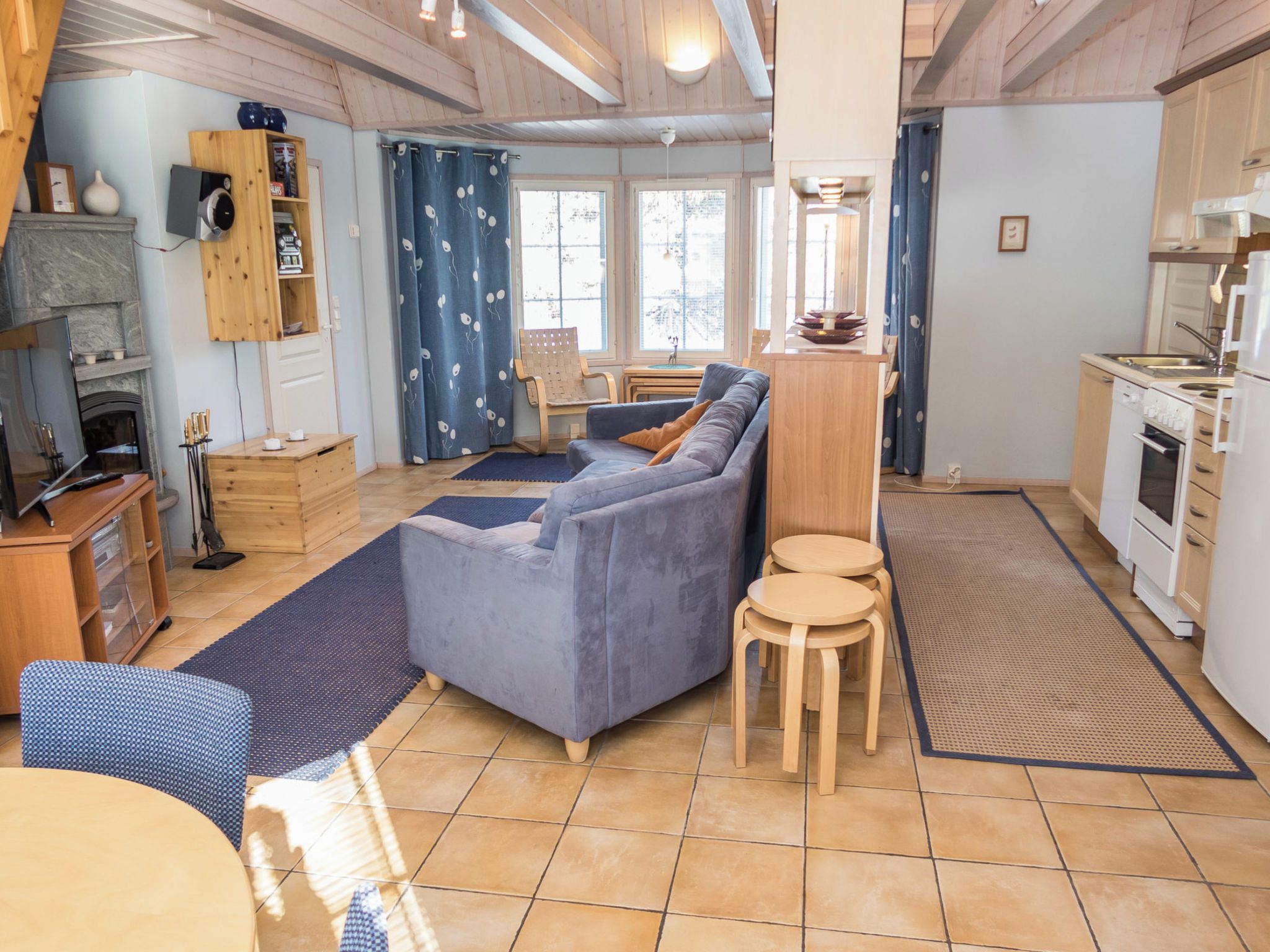 Een gezellige woonkamer met een bank, een eettafel en een keukenhoek.