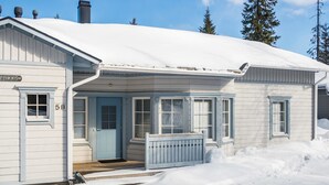 A snow-covered wooden building with a blue door and windows, labeled "5B". - Nelikko b by Interhome (Kuusamo)