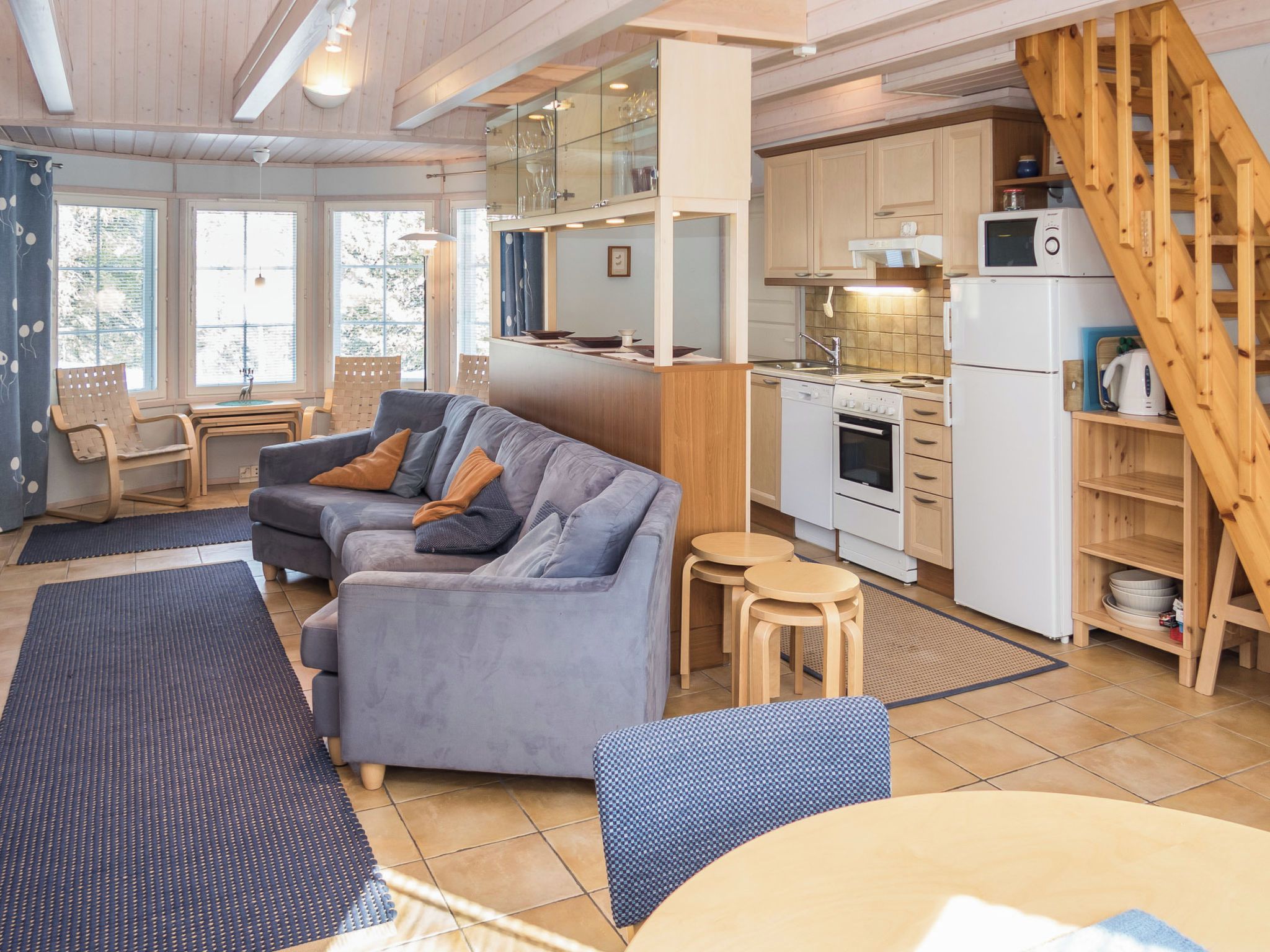 A modern kitchen with wooden cabinets, a built-in oven, and a microwave.