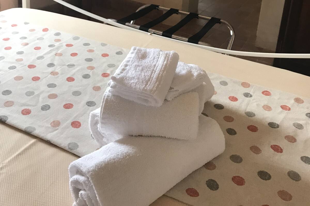 Habitación de hotel con cama, una mesita y baño visible a través de una puerta abierta.