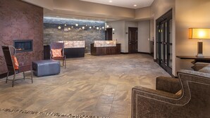 Eine großzügige Lobby mit Empfangstresen, Sitzgelegenheiten und einem Kamin.