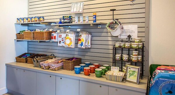 Un espacio de exhibición con cestas, tazas y productos envasados en estantes y mostradores.