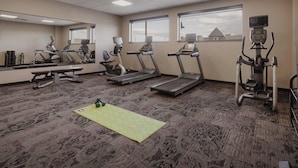 A gym with treadmills, a stationary bike, and a mirror. - Ascent ON Main (PARKER)