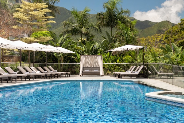 Una piscina al aire libre de temporada, sillones reclinables de piscina