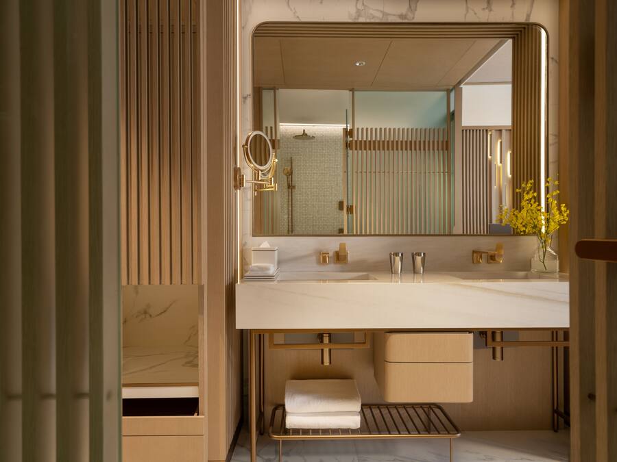 A modern bathroom with a large mirror, dual sinks, and a towel rack.