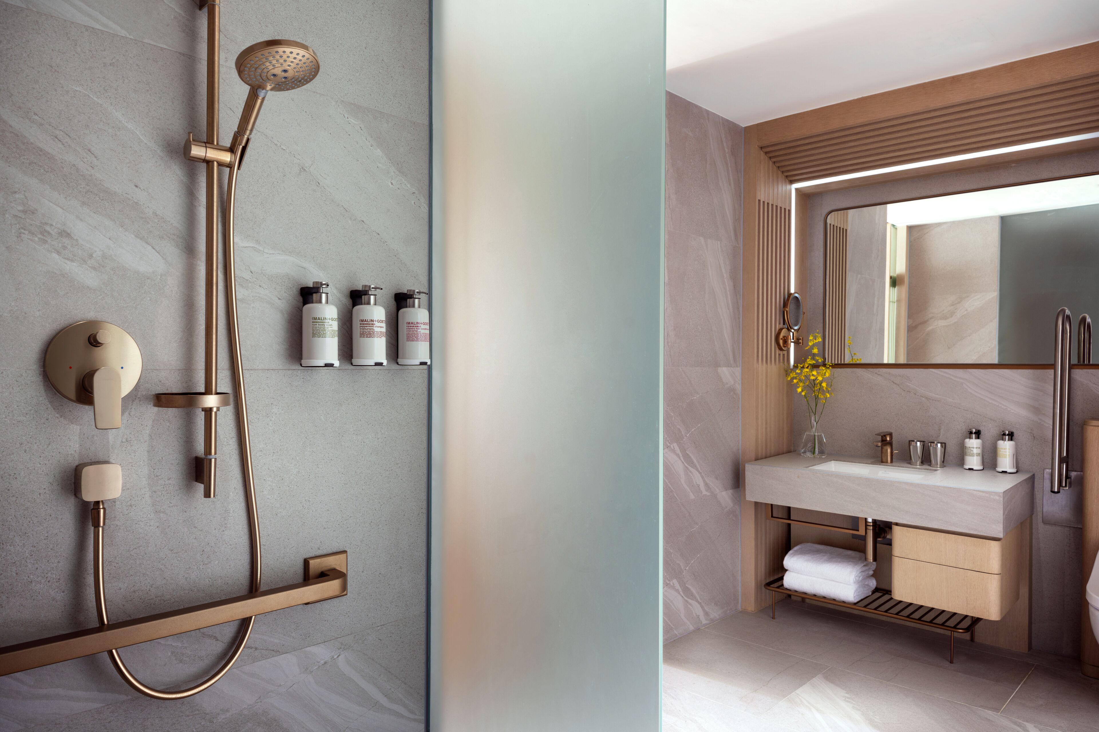 A modern bathroom with a shower, sink, and mirror.