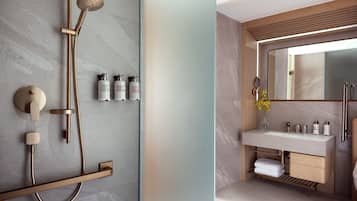 A modern bathroom with a shower, sink, and mirror.
