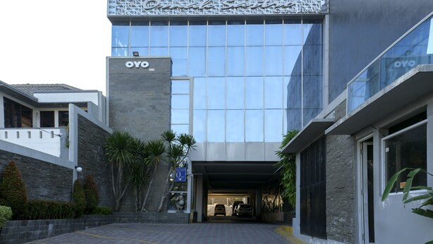 A modern building with a glass facade and a sign reading "OYO". - Grand Omah Sastro (Depok)
