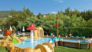 A pool area with slides, a water play structure, and lounge chairs. - Mobile home with air conditioning and pool (Pietra Ligure)