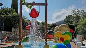 A water play area with a pool, slides, and a red hanging structure. - Mobile home with air conditioning and pool (Pietra Ligure)