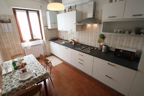 Réfrigérateur, un four, surface de cuisson, vaisselle et ustensiles