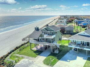 A beachfront property with a large house featuring a balcony and a covered porch. - Literally on beach, unobstructed ocean view (Galveston)