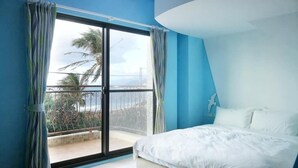 A bedroom with a large sliding glass door to a balcony, a bed, and a unique ceiling design. - Yiting B&B (Checheng)