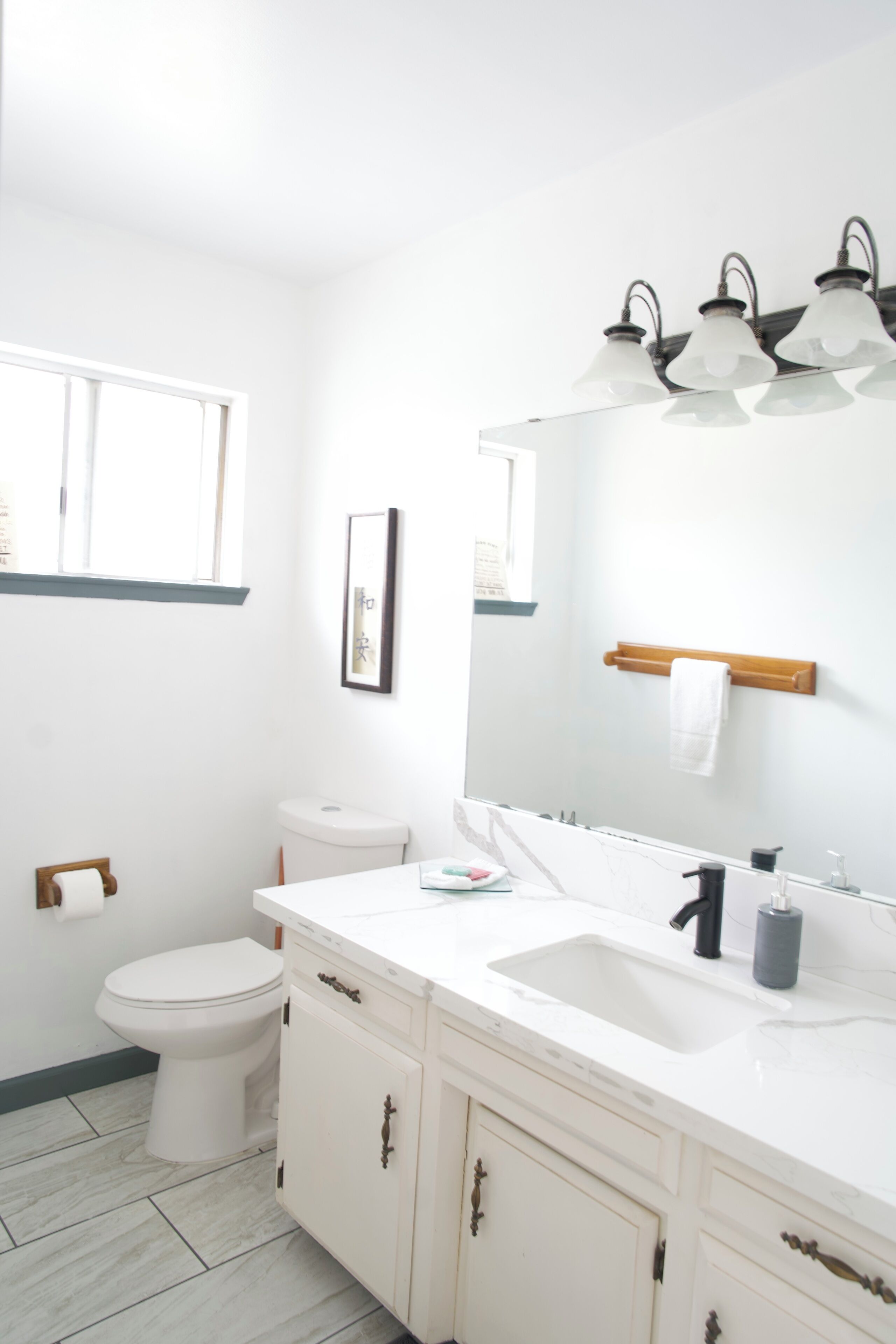 Ein Badezimmer mit Toilette, Waschbecken und Spiegel.