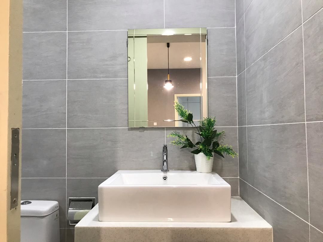 A bathroom with a white sink, a mirror, and a potted plant.
