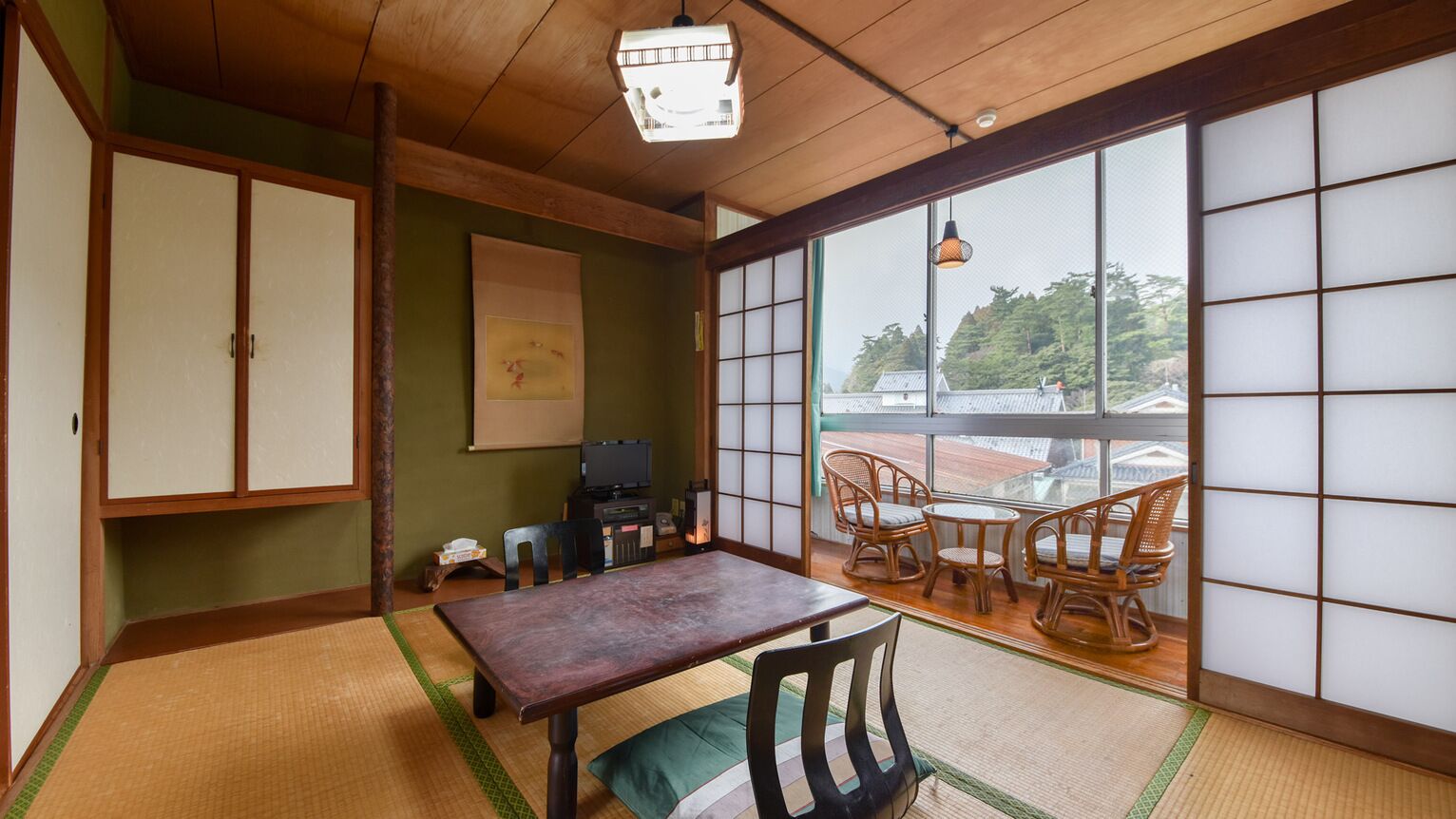 A traditional Japanese room with tatami flooring, a low table, and sliding doors.