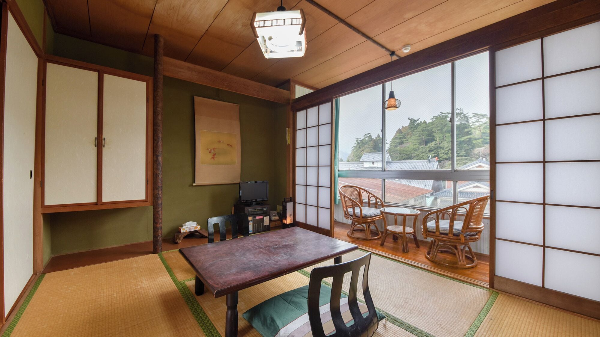 A traditional Japanese room with tatami flooring, a low wooden table, and a view through shoji screens.