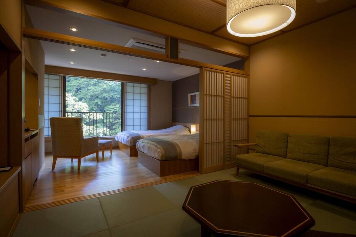 A room with a bed, a sofa, a chair, and a table.