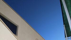 A modern building with a staircase leading to a door, a window, and a clear blue sky. - Luxury apartment INA (Omis)