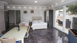 A modern hotel room with a bed, a desk, and a dining area. - Luxury apartment INA (Omis)