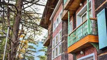 Un edificio a più piani con un balcone e una segnaletica che indica che si tratta di un hotel.