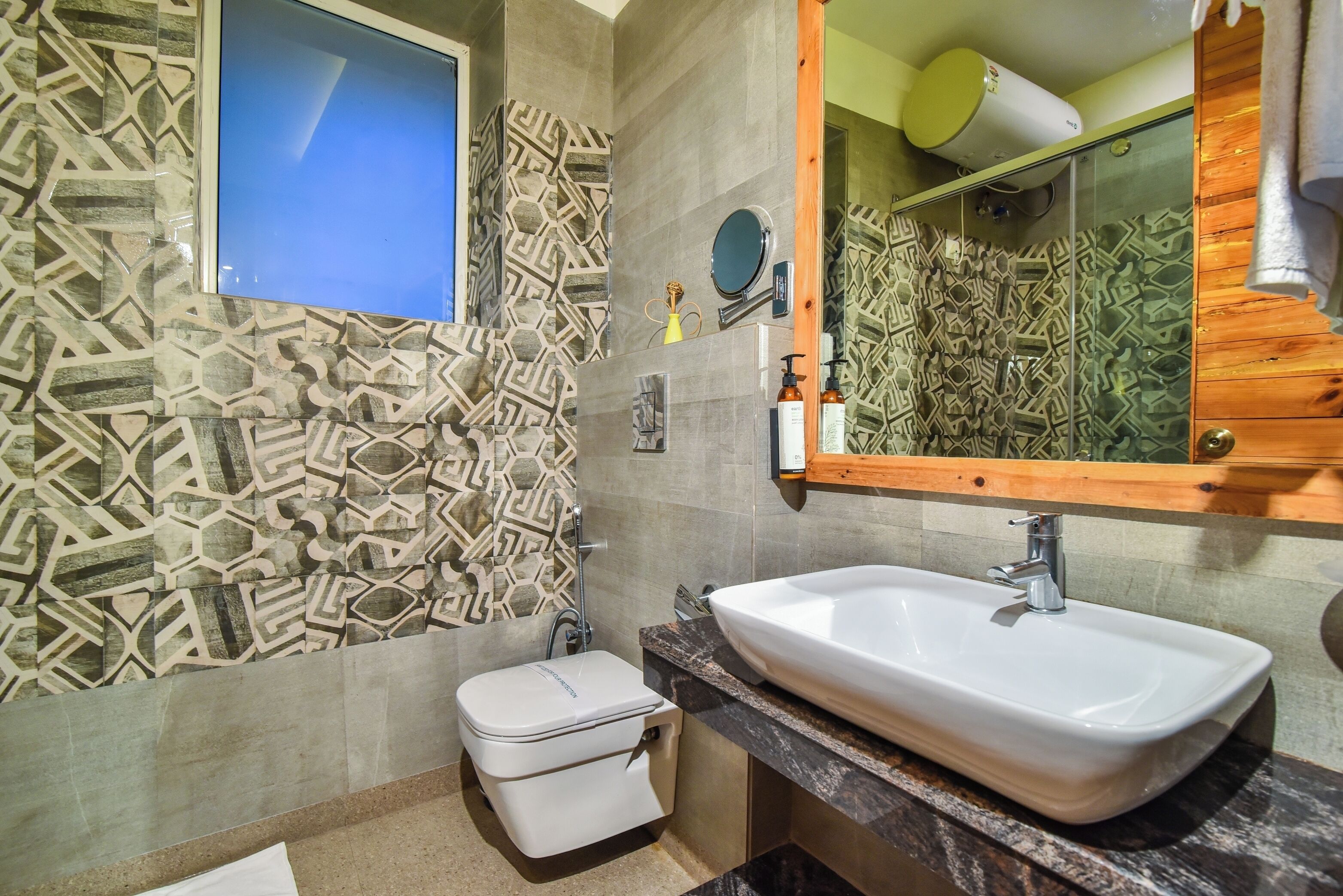 A bathroom with patterned tiles, a white sink, and a toilet.
