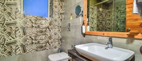 A bathroom with patterned tiles, a white sink, and a toilet.