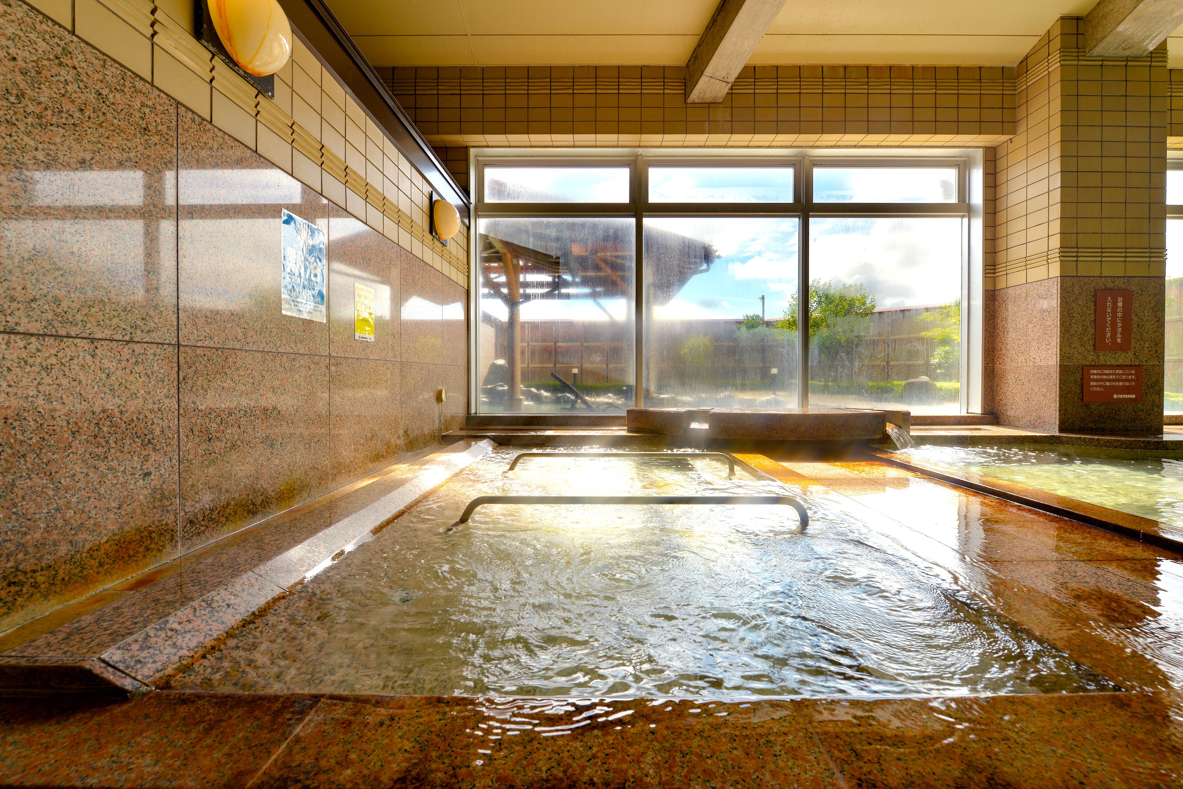 Un espace autour de la piscine, carrelé et doté d’une grande fenêtre.