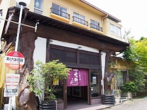 Il s’agit d’un bâtiment à l’architecture traditionnelle, doté d’un auvent en bois au-dessus de l’entrée. Des panneaux indiquent la présence d’un restaurant et d’un service de dépôt/reprise.