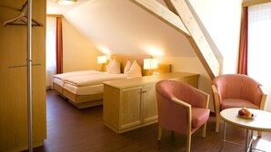 A bedroom with a bed, bedside tables, a wardrobe, a desk, and two chairs. - Hotel Landgasthof Linde (Deggenhausertal)