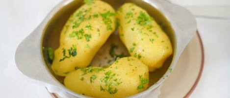 A bowl of boiled potatoes garnished with parsley.