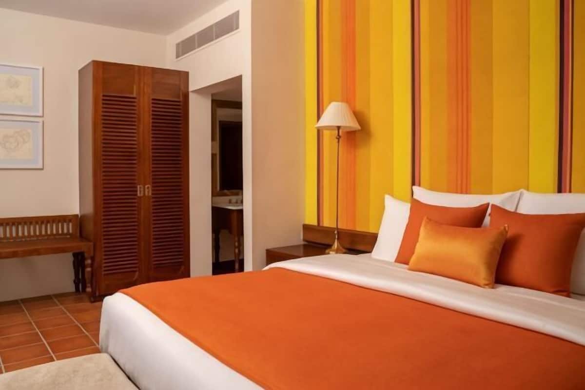 Una habitación de hotel con cama, escritorio y armario.