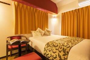 Una camera d'albergo con un letto, una sedia, un tavolo e una panca rossa.