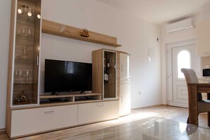 Relax in this stylish living room with an entertainment unit featuring a flat-screen TV and a glass-fronted cabinet.