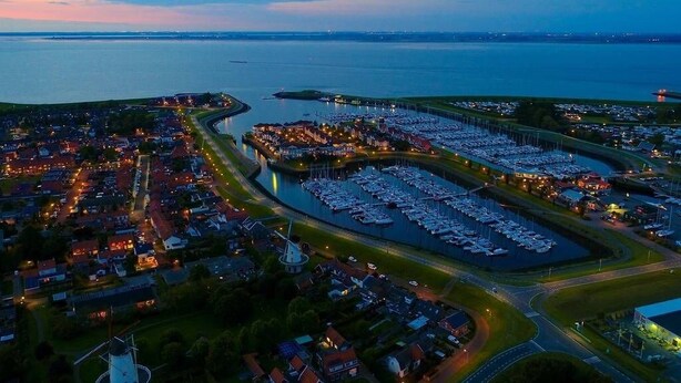 An aerial view of a coastal town with a marina, roads, and residential areas. - Holiday home for 6 people in Wemeldinge (Wemeldinge)