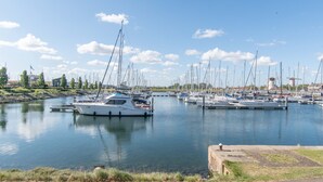 A marina with multiple sailboats docked, calm water, and a clear sky. - Holiday home for 6 people in Wemeldinge (Wemeldinge)