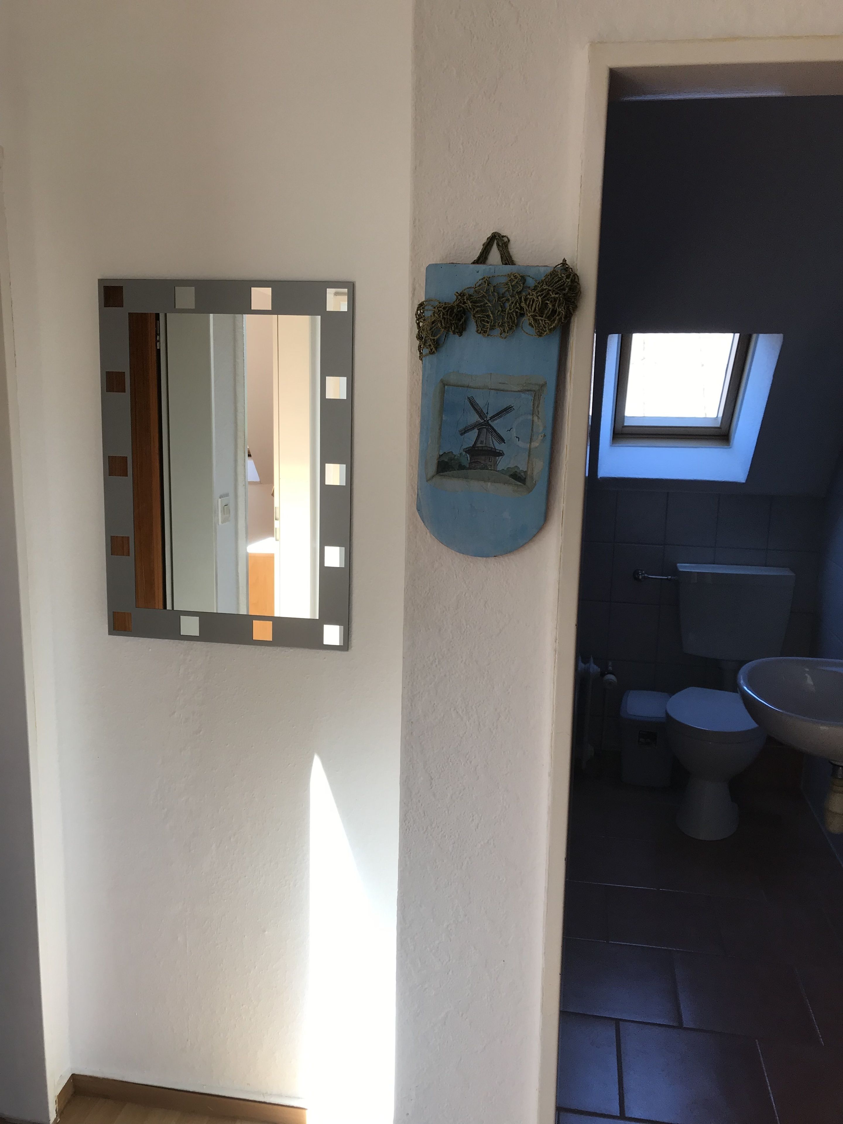 A bathroom with a skylight, a sink, and a toilet.